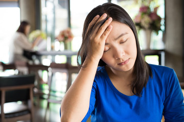 Woman has headache in the cafe