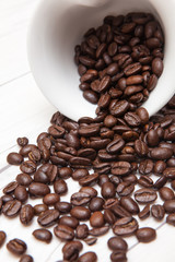 coffee beans pouring out, white ceramic tea set on wooden desk