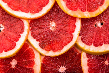 Sliced grapefruits, background, natural texture of citrus, top view, close-up