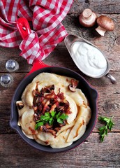 Dumplings with mashed potatoes, fried mushrooms, bacon and crispy onions.