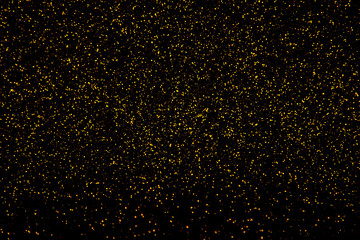 Gold glitter glowing on black background