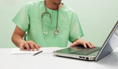 Doctor working with computer notebook at desk