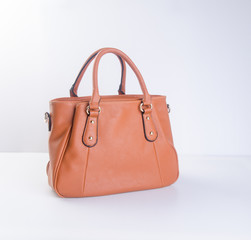 bag or brown leather woman handbag on background.