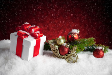 Fototapeta na wymiar Christmas balls and gift box on snow.