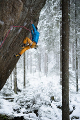 Outdoor winter sport. Rock climber ascending a challenging cliff. Extreme sport climbing. 