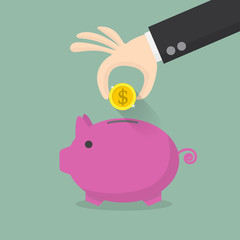 hand putting coin into the piggy money box