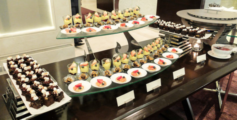 Catering Dessert and Bakery on Buffet Line with Orange Sun Light Shade at The Corner, Selective Focus in The Middle, Indoor Shot