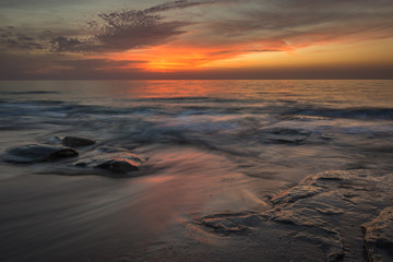 Fototapeta na wymiar silky water on a vivid orange sunset