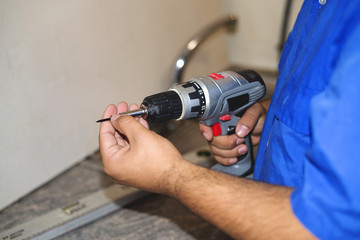 Construction worker using an electric screwdriver