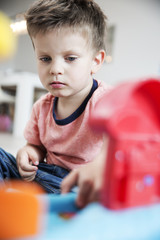 Junge mit Spielzeug zuhause im Wohnzimmer, Köln