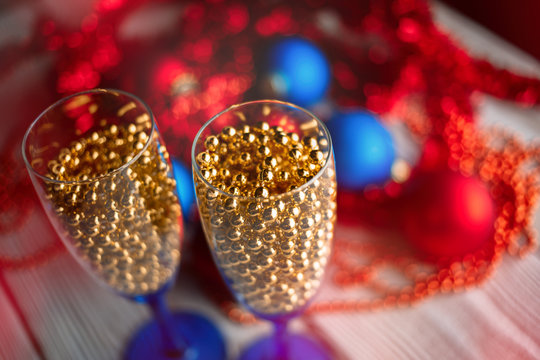 Serving Table. new years eve party table with champagne. Champagne glasses. Celebration theme. New dekor- beads, garland instead of champagne. Festive glasses with champagne.