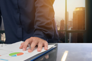close up of business man hand holding pen for working on laptop