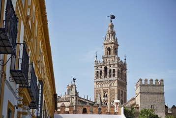 Fototapeta na wymiar Giralda, famous bell tower of the Seville Cathedral in Spanish city of Sevilla, built as a minaret and rebuilt as a tower of famous church as a symbol of Arab and Moorish architectural period in Spain
