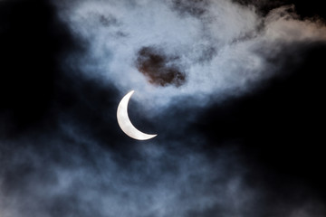 Partial solar eclipse through clouds