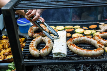 Grilling sausages and quail on the market showcase