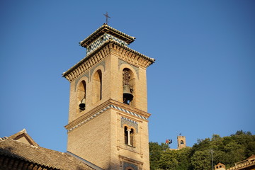 Fototapeta na wymiar Top of the church in Granada in southern Spain as a typical Spanish bell tower, symbol of Spanish religious architecture and design 