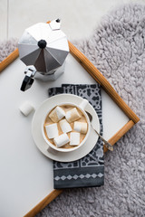 Warm cozy home. Tray and cup of coffee with marshmallows 