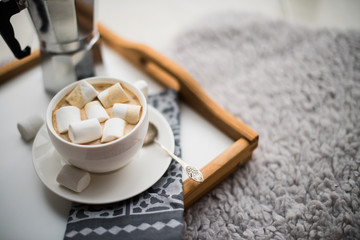 Warm cozy home. Tray and cup of coffee with marshmallows 