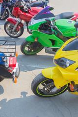 red green and yellow motorcycle in parking lot in row close up