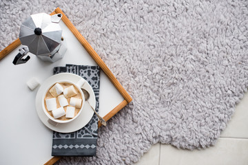 Warm cozy home. Tray and cup of coffee with marshmallows 