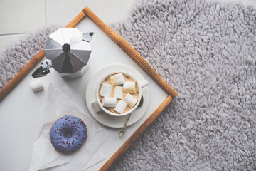 Warm cozy home. Tray and cup of coffee with marshmallows 