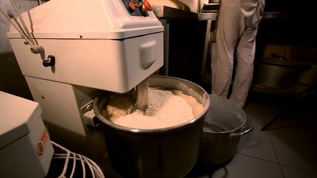 Bread Mixer In Bakery, mixing dough for baguettes in a bakery machine for mixing dough, top view, adds the ingredients
