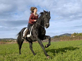 Fototapeta na wymiar riding girl and black stallion
