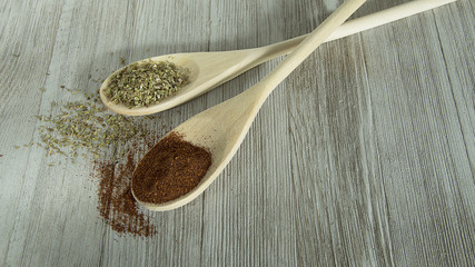 two wood spoons with spices on them