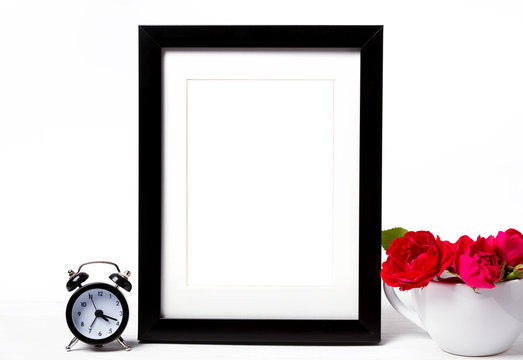 Empty frame mock-up, red roses in a cup and clock