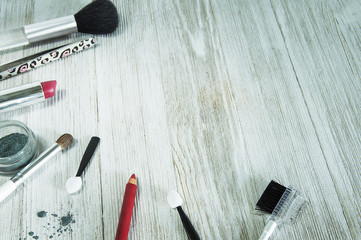 makeup tools scattered in corner on wood