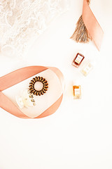 Flat lay for fashion blog and social media. Woman's golden glamour beauty accessories on a white background. Lingerie, jewelry, perfumes, spiral hair ties and hair clips. Copy space for text