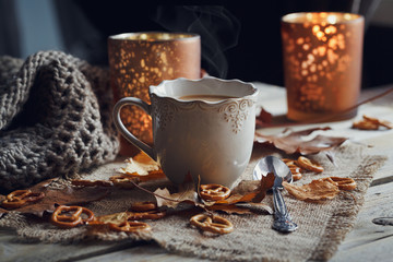 Autumn leaves, hot steaming cup of coffee and a warm scarf