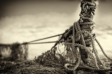 Tied up ship rope on Norway beach in sepia