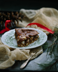 Traditional homemade christmas cake holiday dessert with cranberry in new year tree decorations frame on vintage wooden table background. Rustic style