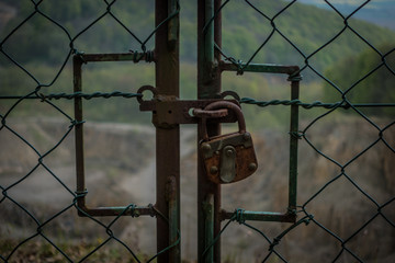 The old and rusty lock on a metal gate.