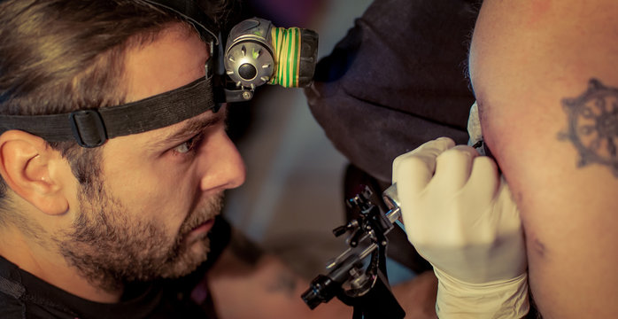 Artist making tattoo on male customer