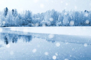Winter landscape with frozen river and forest in the frost