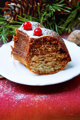 Piece of christmas pudding cake decorated with berries sprinkled