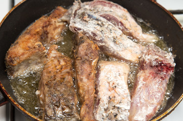 fish is fried in a pan