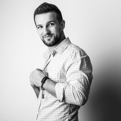 Black-white portrait of elegant young handsome man in stylish shirt.