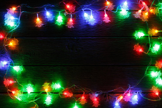 christmas lights border on black wood background