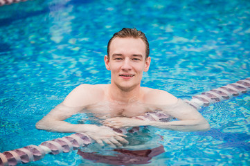 Portrait of young sexy handsome man in swimming pool