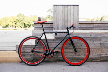 Red bycicle parked near bench in park