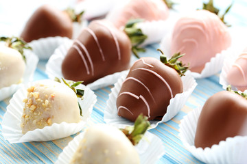 Strawberries covered in chocolate on a blue wooden table