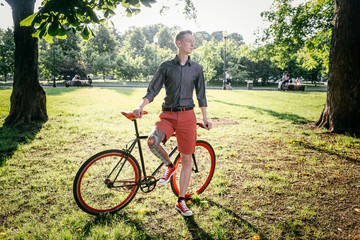 Naklejka premium Hipster with bycicle and tattoo on leg