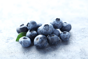 Ripe and tasty blueberries on grey wooden table