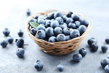 Ripe and tasty blueberries on grey wooden table