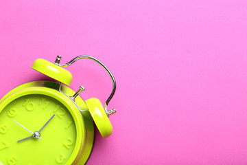 Green alarm clock on a pink background