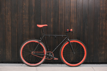 Red bycicle parked near the brown wall