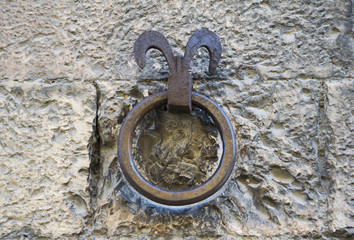Fototapeta na wymiar Big stained metal ring on the wall. Tuscany, Italy.